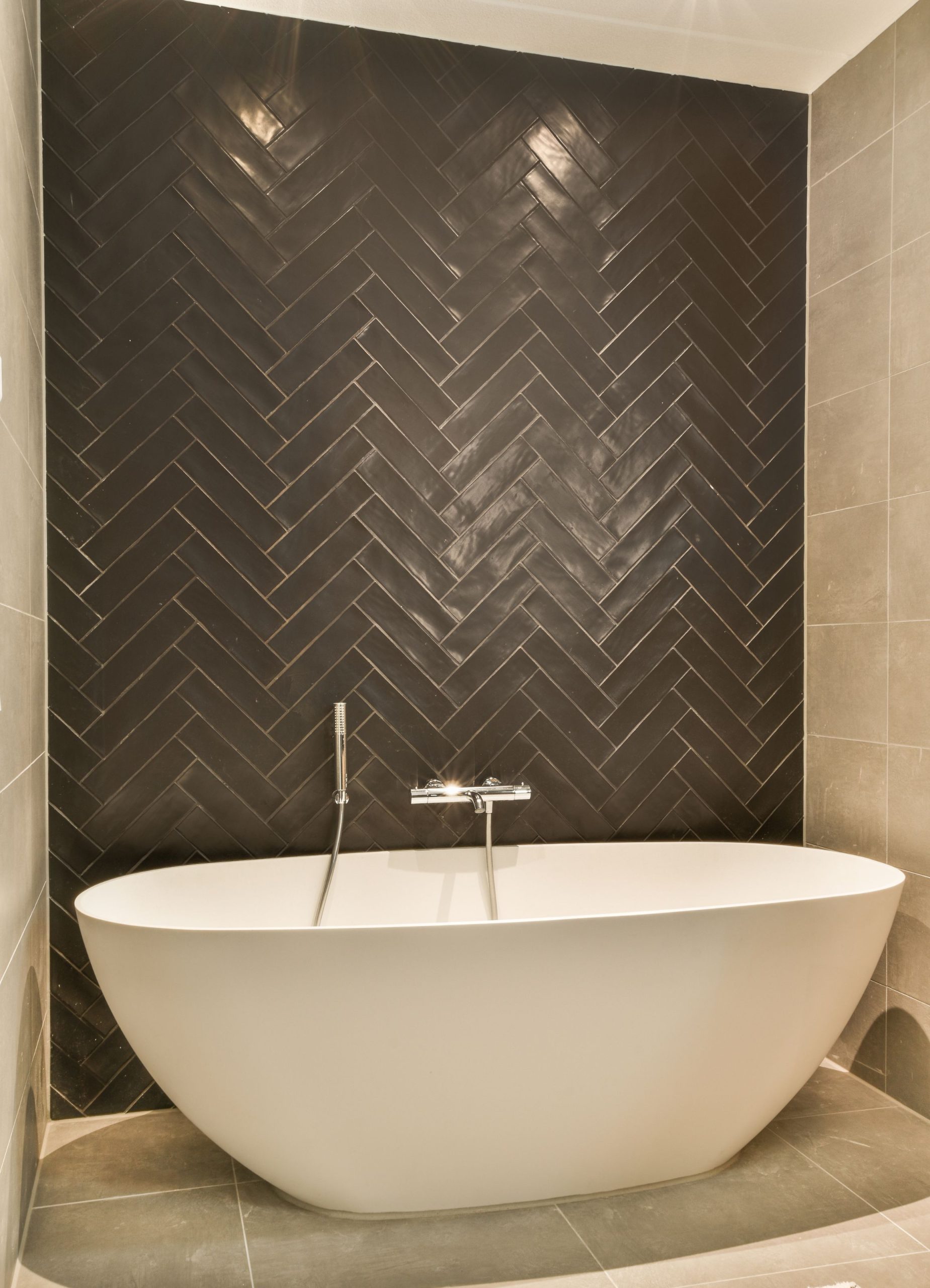 Salle de bain grands carreaux sol et carrelage métro noir mur pose en chevron. Cerame Carrelage