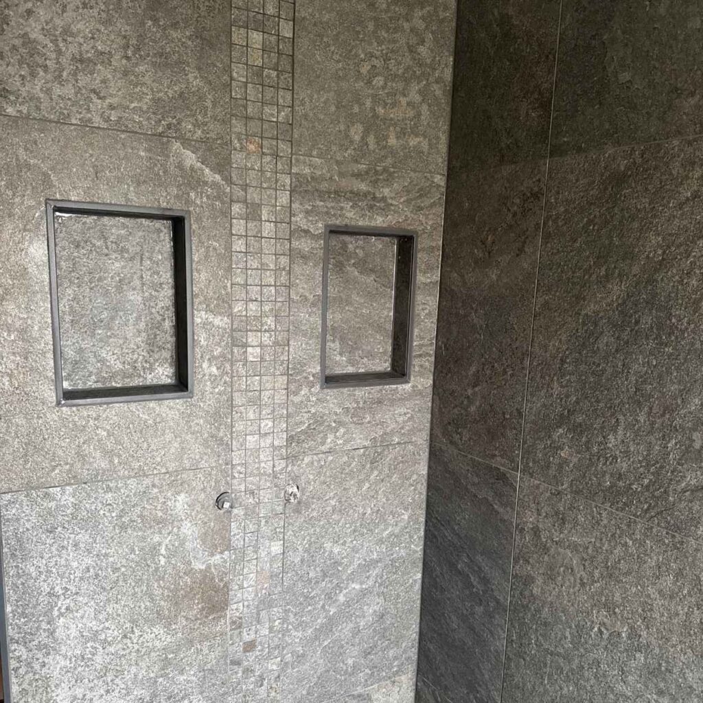 Deux niches intégrées dans un mur carrelé de douche