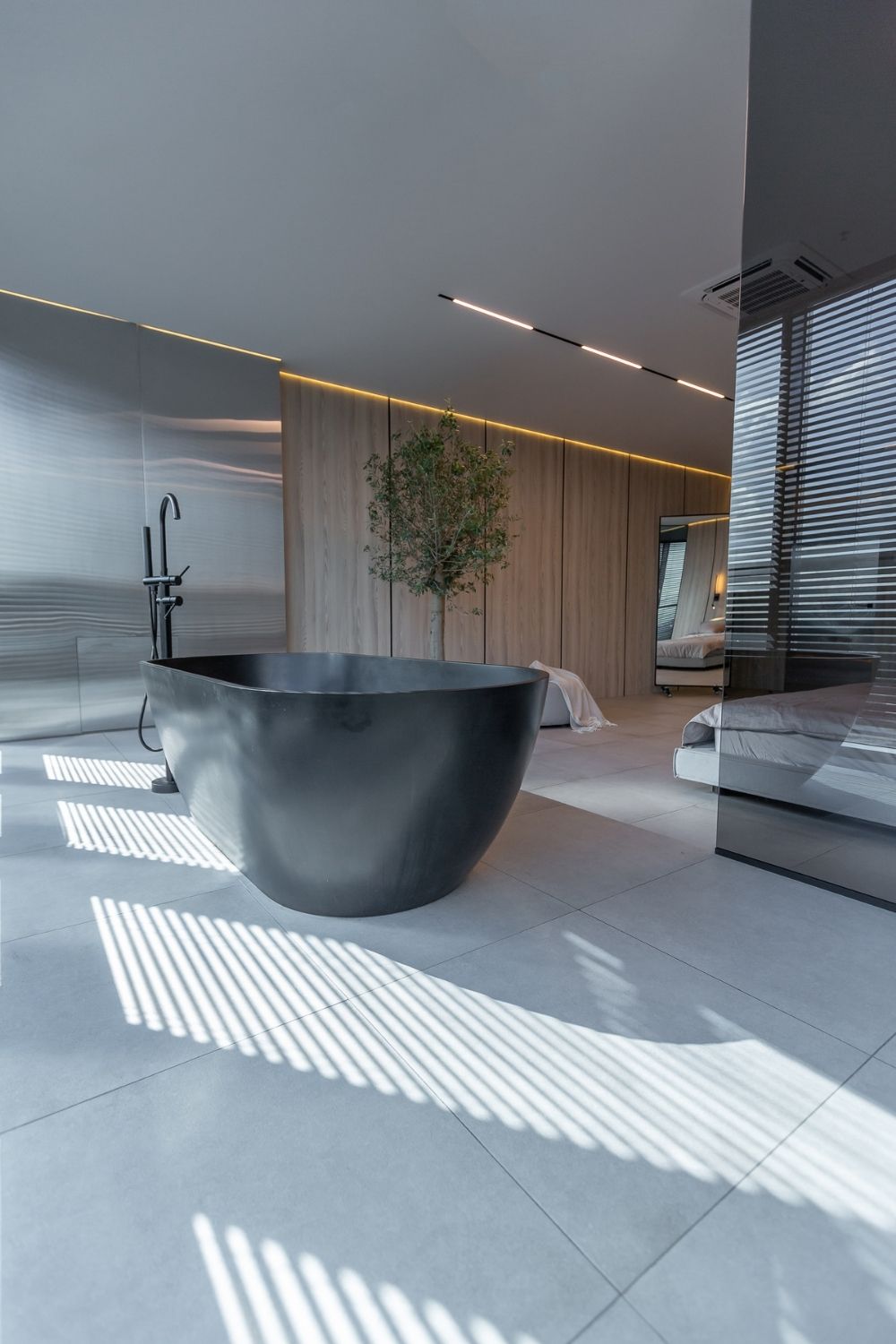 Salle de bain contemporaine avec baignoire noire et carrelage grand format