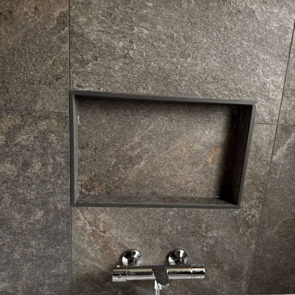 Niche de douche intégrée dans un carrelage gris foncé